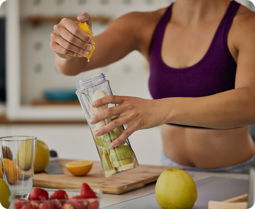lady is squeezing lemon juice by hand into a jar with vegetables in kitchen
